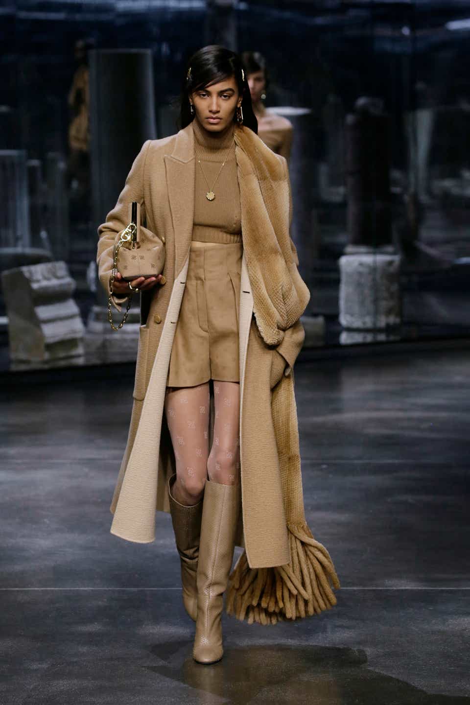 Model wearing a camel coat and matching fur scarf at the Fendi fall '21 show.