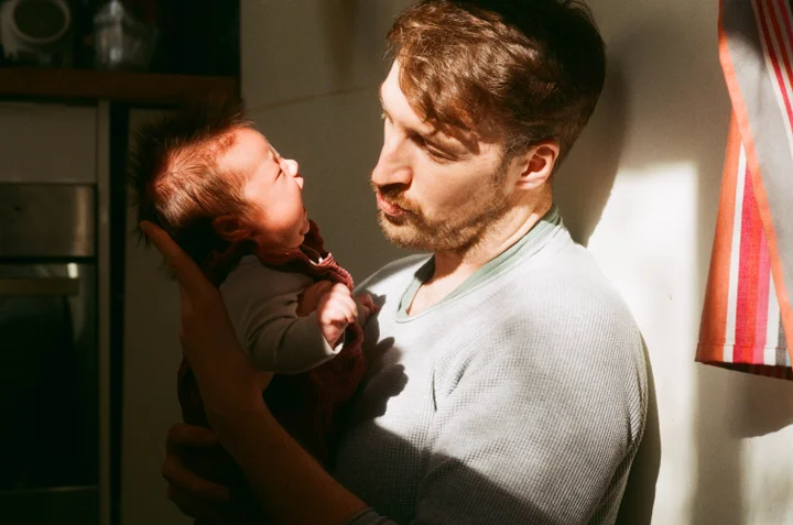 Father holds young baby gently