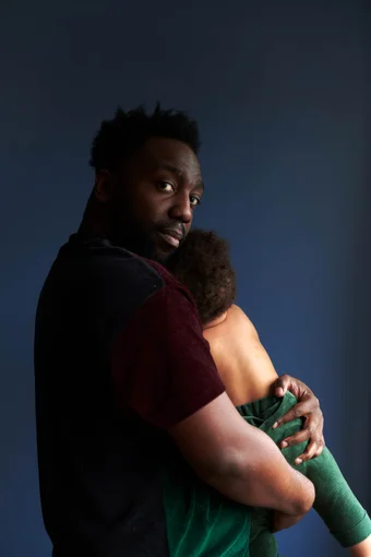 Father holds his son against blue background