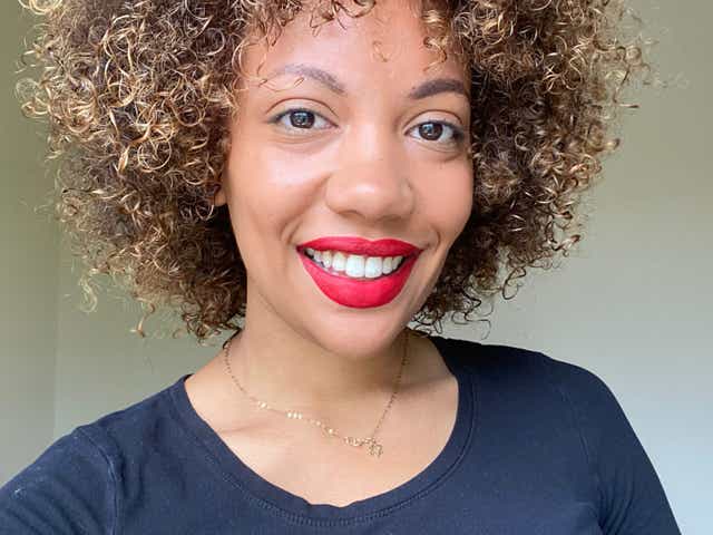 Image of writer Jessica smiling wearing red lipstick. Her hair looks healthy and curls are visibly more defined