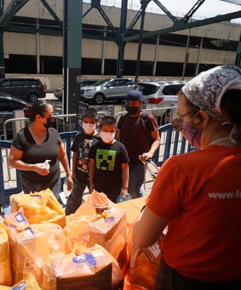 A local family receives food items as Food Bank For New York City teams up with the New York Yankees.