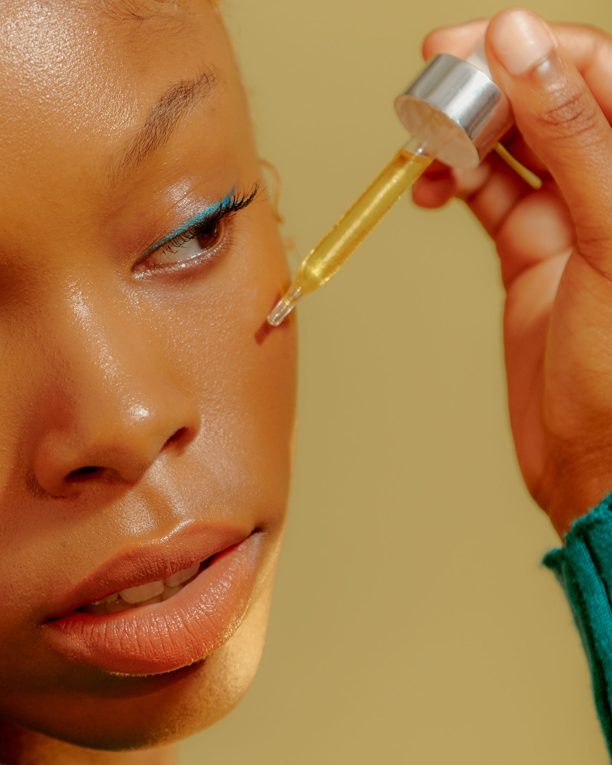 Close up of person applying serum to their face