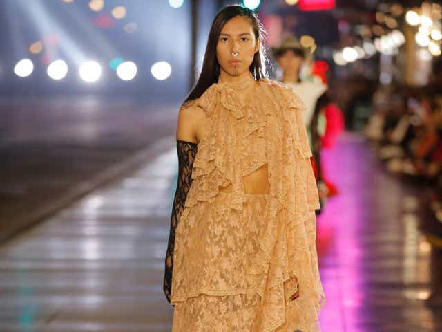 Quannah Chasinghorse wearing a lace gown while walking for Gucci's Love Parade show.