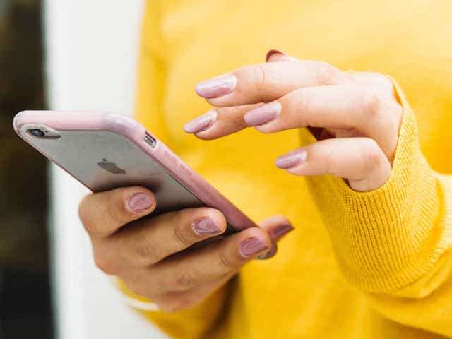 An image of a woman typing on her phone.