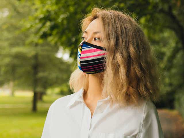 Woman in a park wearing a cloth mask.