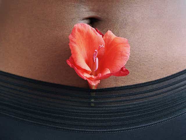 Woman in black underwear with a red flower resting in the waistband