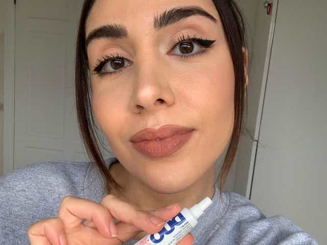 Selfie of Jacqueline holding lash glue after TikTok's brow lamination hack