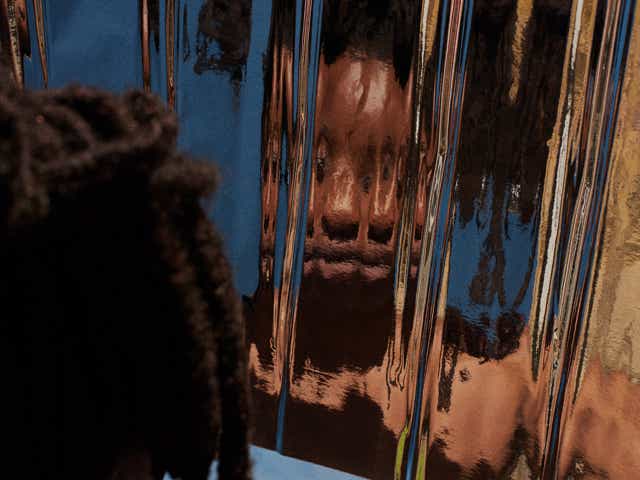 Black woman looking at her reflection.