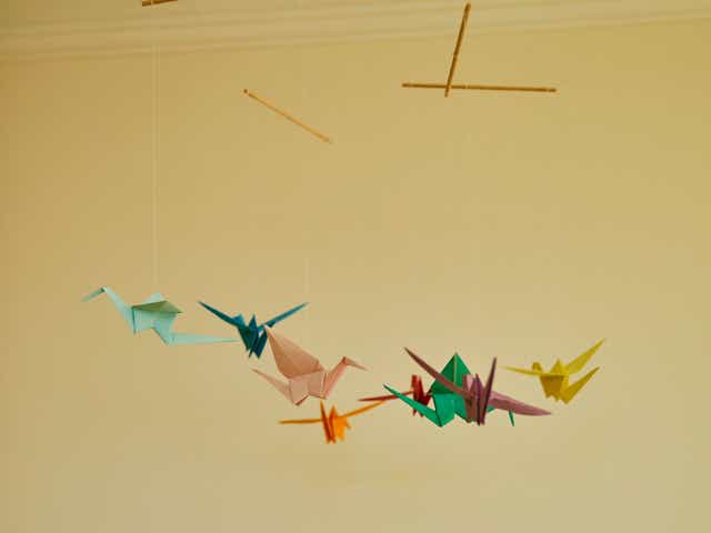A cot mobile made out of origami paper cranes.