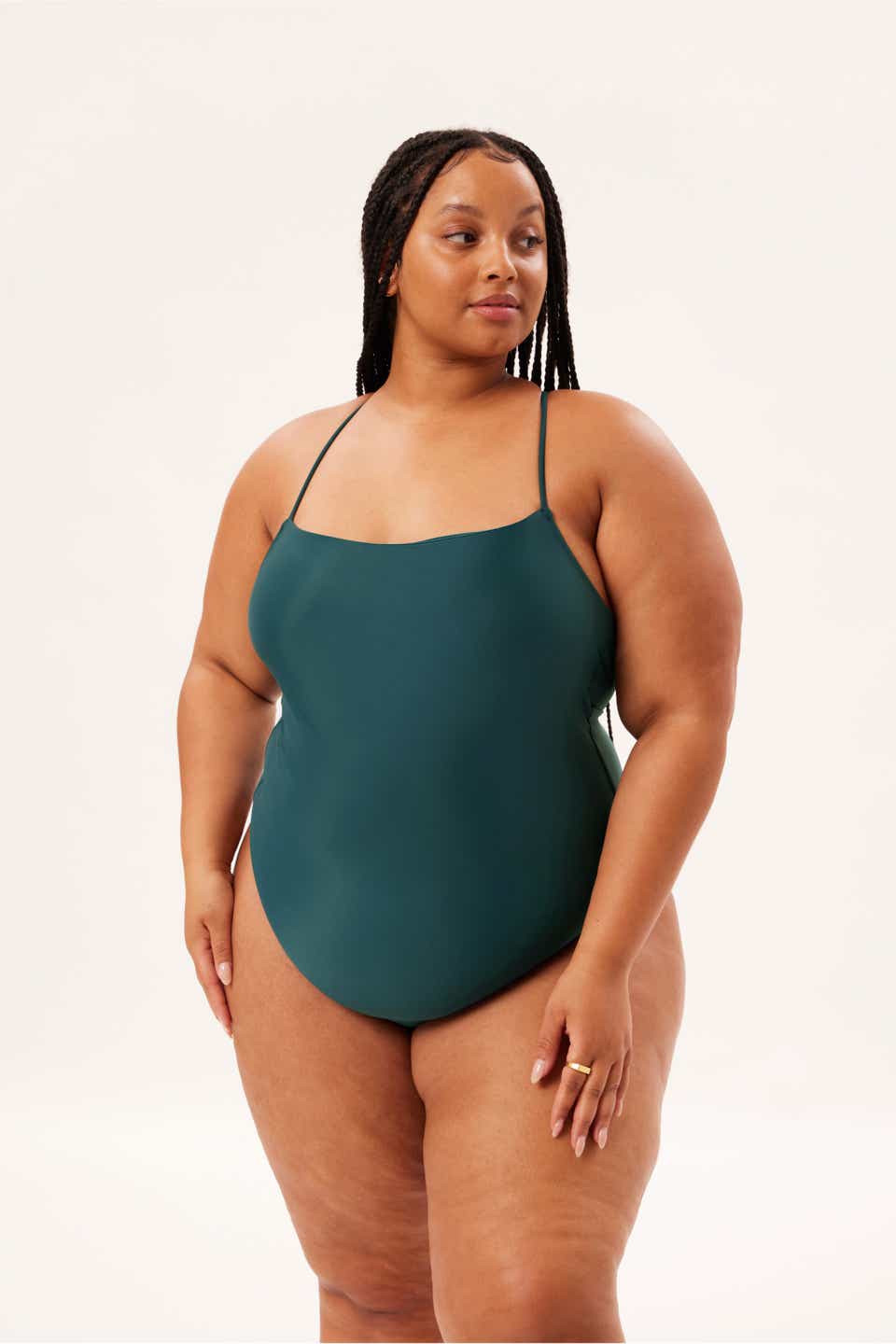 A model wearing the Girlfriend Collective stand-neck one-piece in the color of the sea. 