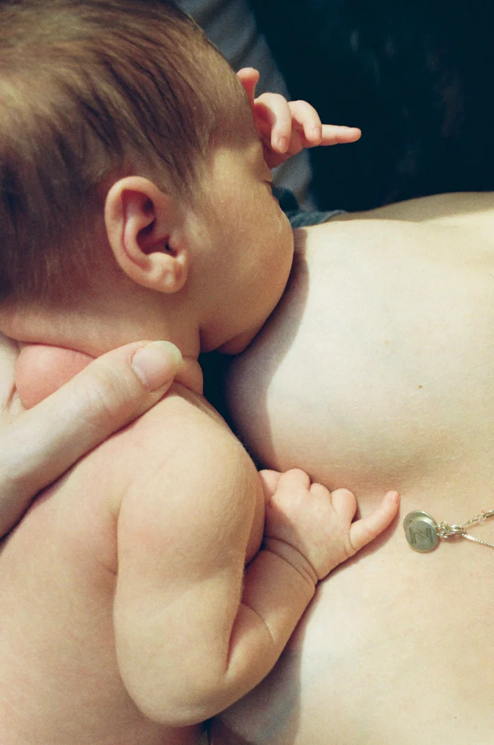 Photo of a newborn baby being breastfed by the photographer Sophie