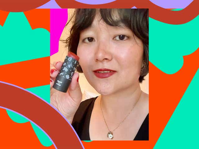 R29 writer Jinnie Lee holding a lipstick.