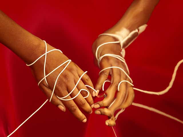 A Black woman's hands entangled in rope
