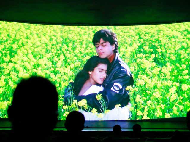 Bollywood actors Shah Rukh Khan (R) and Kajol (L) are seen on the screen during the screening of "Dilwale Dulhania Le Jayenge" (The Big Hearted Will Take the Bride) inside Maratha Mandir theatre in Mumbai December 11, 2014.