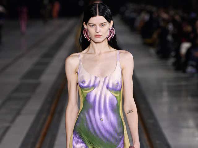 a model wears a yellow, purple, and green trompe l'oeil dress from y/project