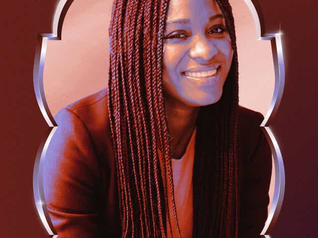 A photo of a Black Latina smiling while in a business suit