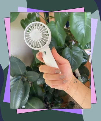 Handheld mini fan in front of plants