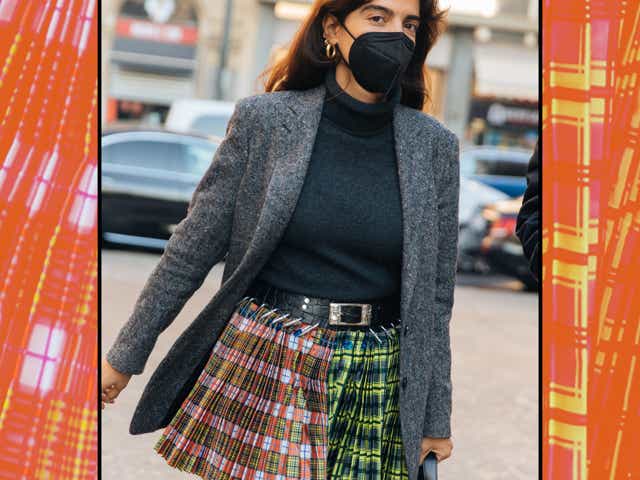 Georgia Tal wears a gray blazer, black top, and Chopova Lowena plaid print pleated black belt skirt outside the Etro show during the Milan Men's Fashion Week - Fall/Winter 2022/2023 on January 16, 2022 in Milan, Italy
