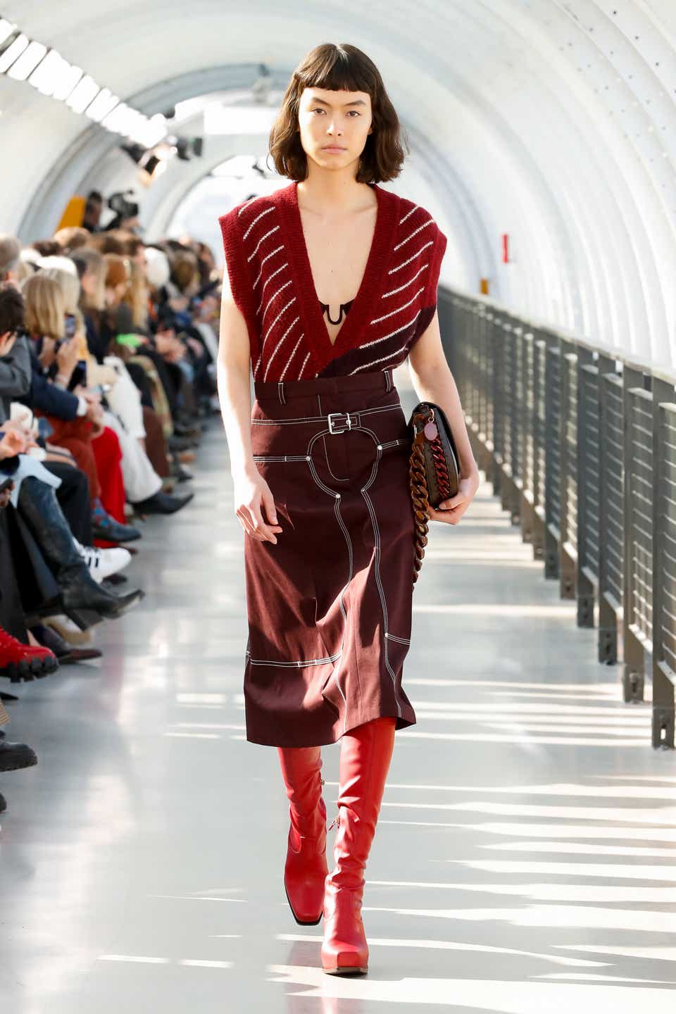 A model wearing a red striped sweater vest on the Stella McCartney Fall 2022 runway show.