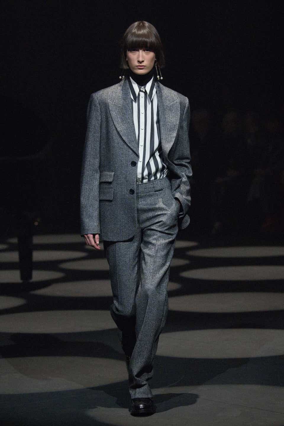 A model wearing a gray suit with a striped shirt on the Erdem Fall 2022 runway show.