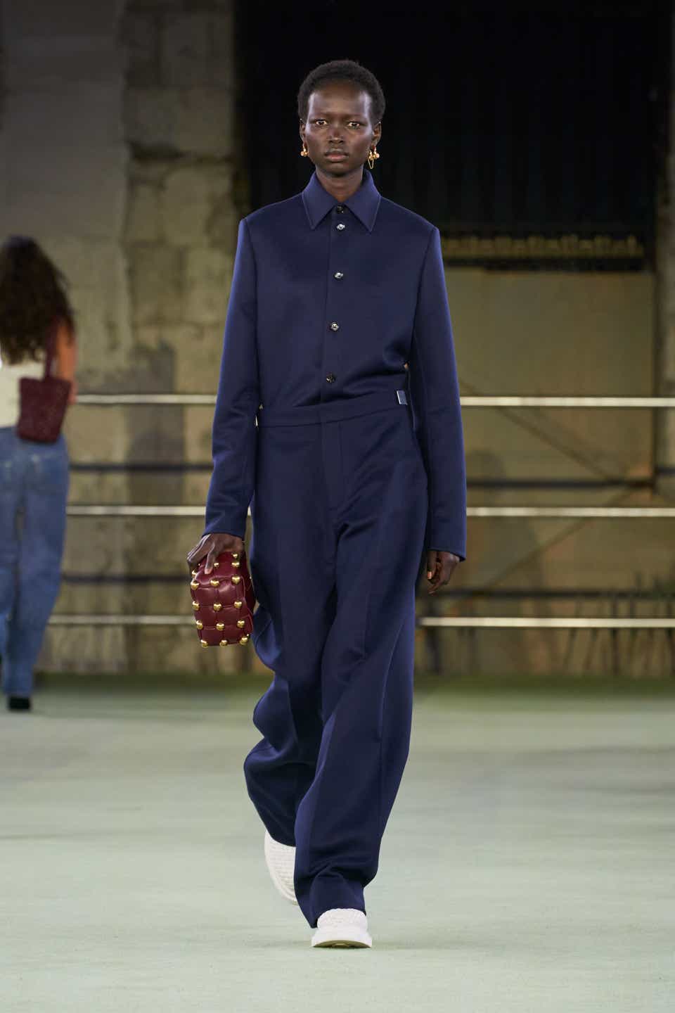 A model wearing a navy button-down and trouser set on the Bottega Veneta runway.