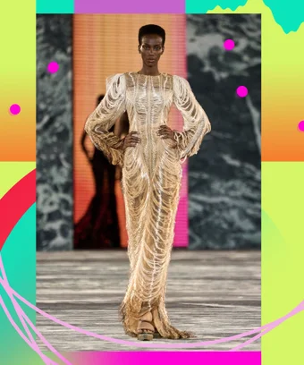 A model in a gold gown on the runway of Balmain Spring 2023.