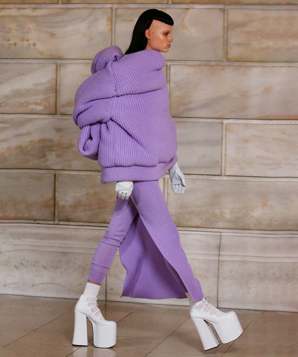 A model wearing a purple look with white Mary Jane platforms.