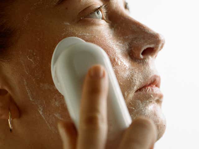 Closeup of a woman using a cleanser on her face