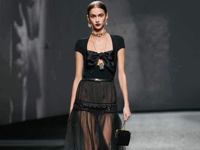 A model wearing a black naked dress on the Chanel Spring 2023 runway.