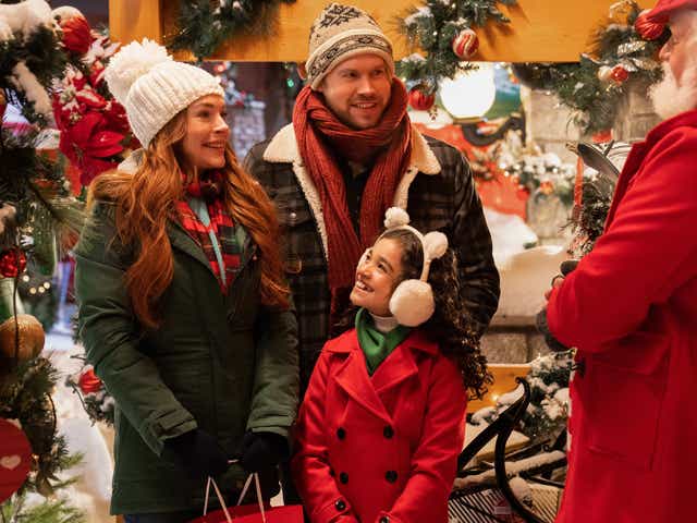 Falling For Christmas. (L to R) Lindsay Lohan as Sierra, Chord Overstreet as Jake, Olivia Perez as Avy, Bus Riley as Chestnut Vendor in Falling For Christmas. Cr. Scott Everett White/Netflix © 2022.
