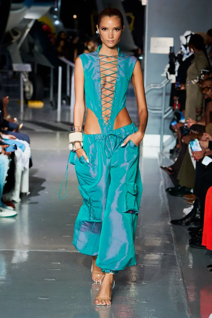 A model wearing iridescent blue cargo pants at LaQuan Smith Spring 2023 runway.