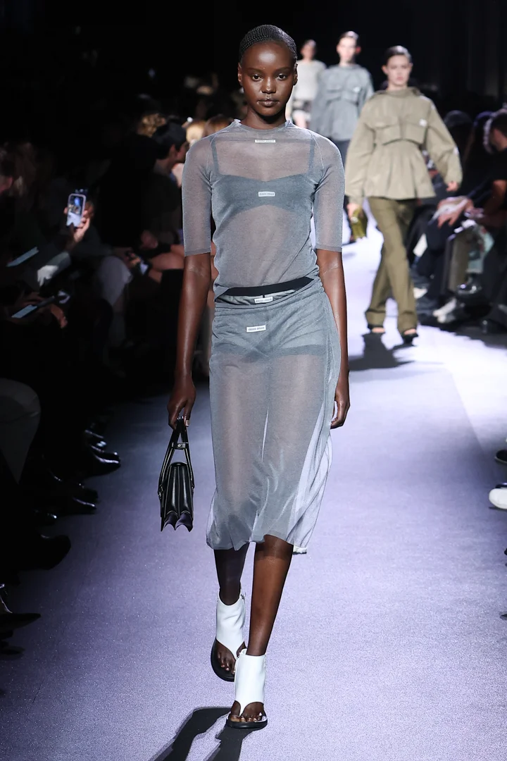 A model wearing a sheer dress over underwear at Miu Miu Spring 2023 runway.