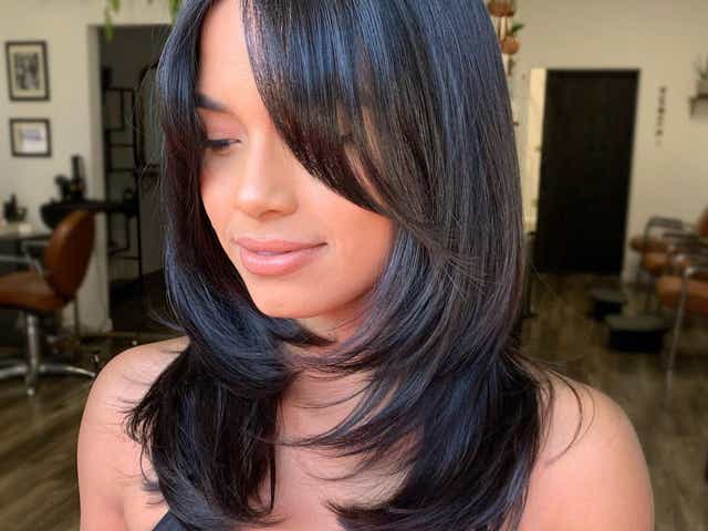 Black haired woman with a mid length 'oval layer' haircut