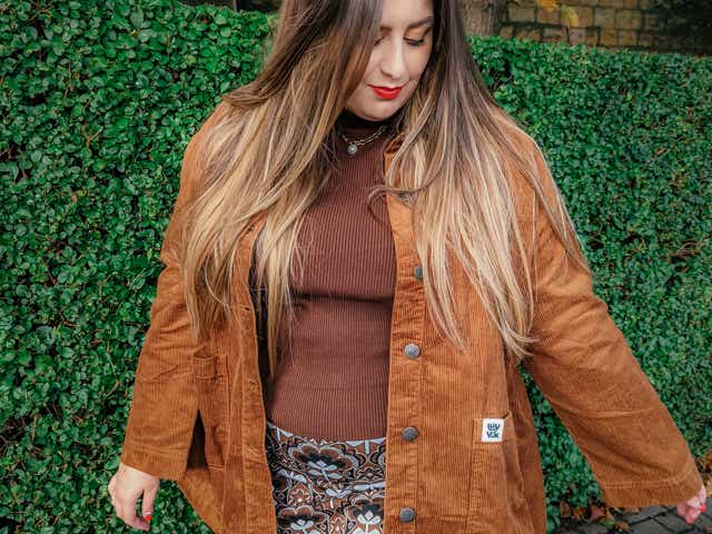 Mollie wearing a brown corduroy jacket, brown top, pattern skirt and tights