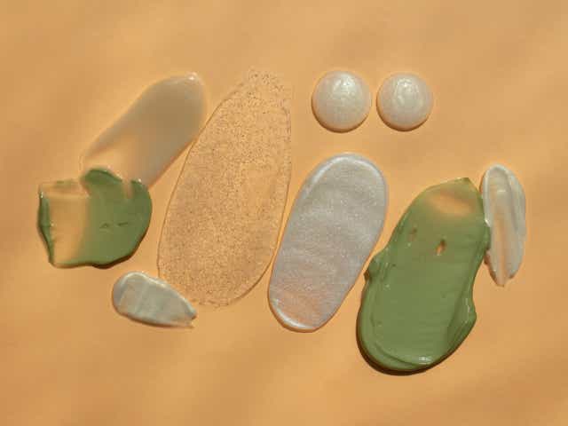 Various skincare swatches against an orange background