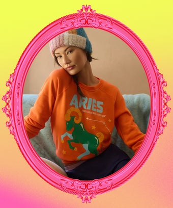 Ein orange-farbenes Sweatshirt mit einem grünem Widder Design