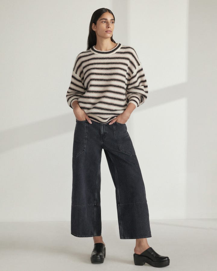 A model wearing black gardener jeans from Everlane