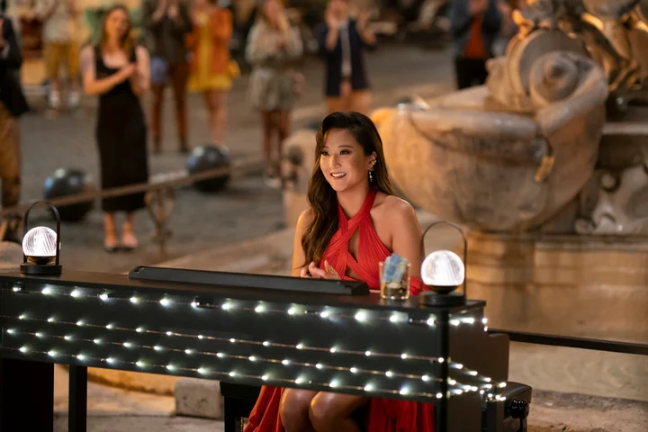 Ashley Park as Mindy in Emily in Paris season four wearing a red cut-out halter gown