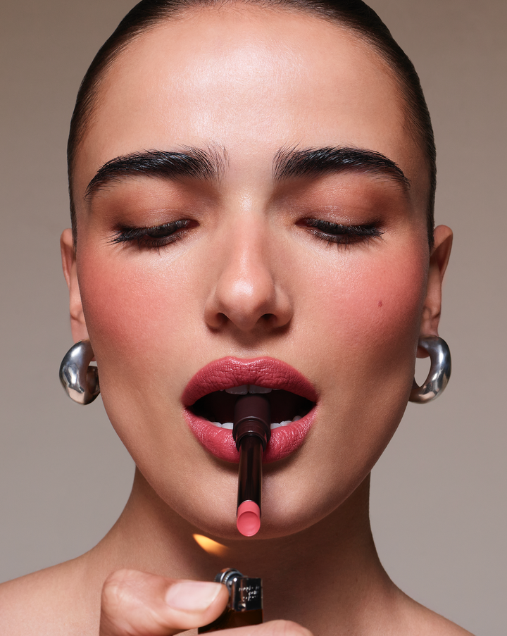 woman with a lipstick in her mouth